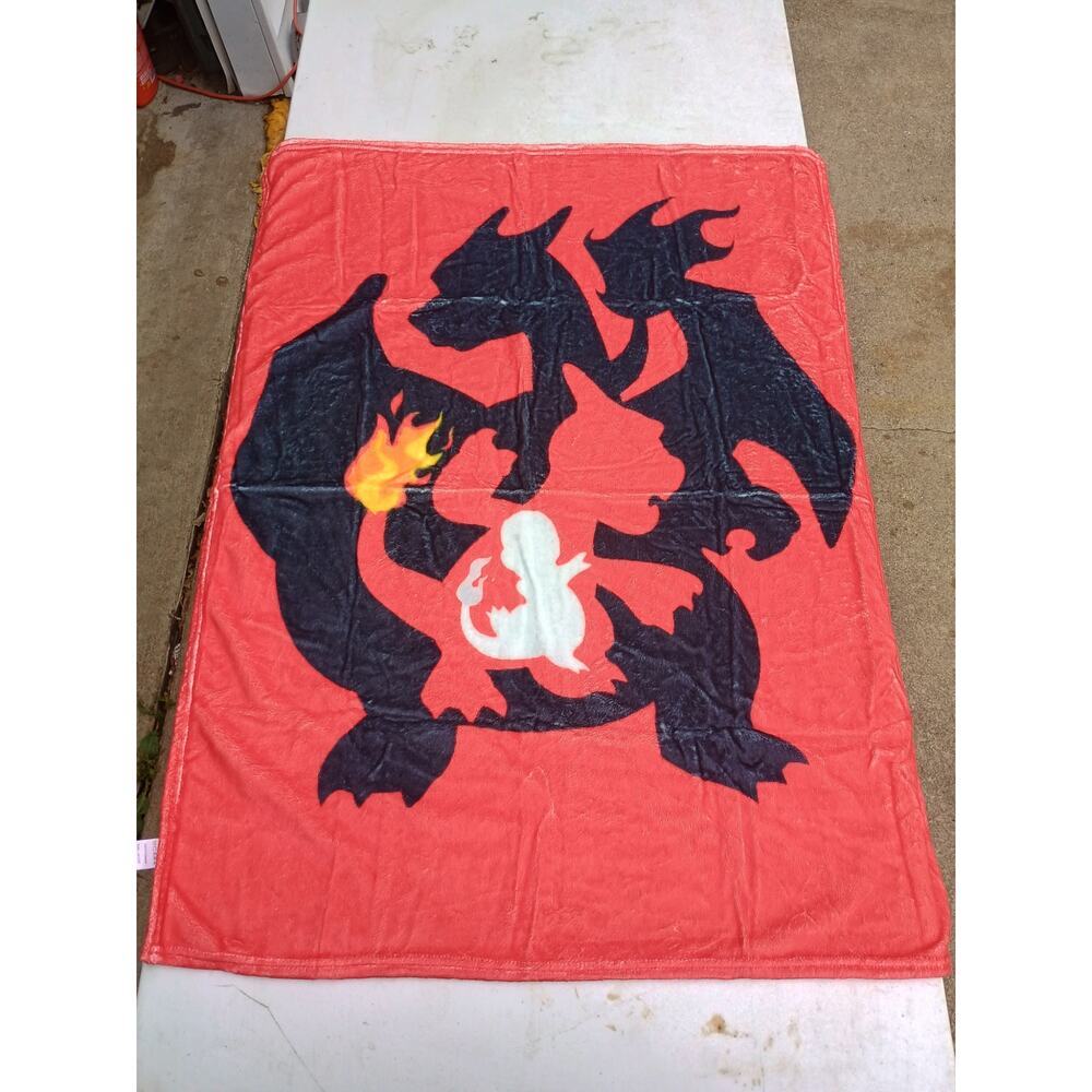 red mini blanket featuring the Pokémon Charizard and its pre-evolutions.